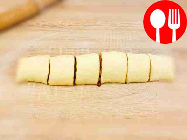 Скрутите пласт теста в рулет и нарежьте его на...