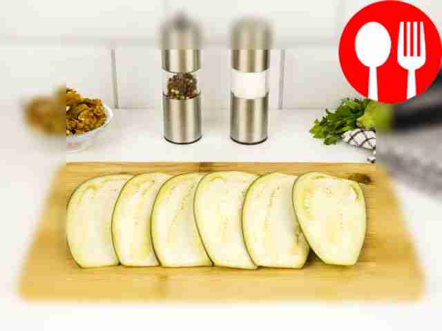 Разрежьте баклажаны вдоль на пластины....