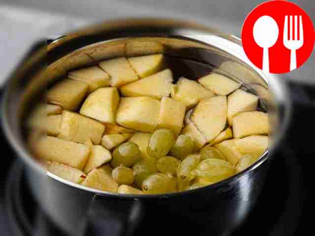 Выложите яблоки и виноград в кастрюлю...