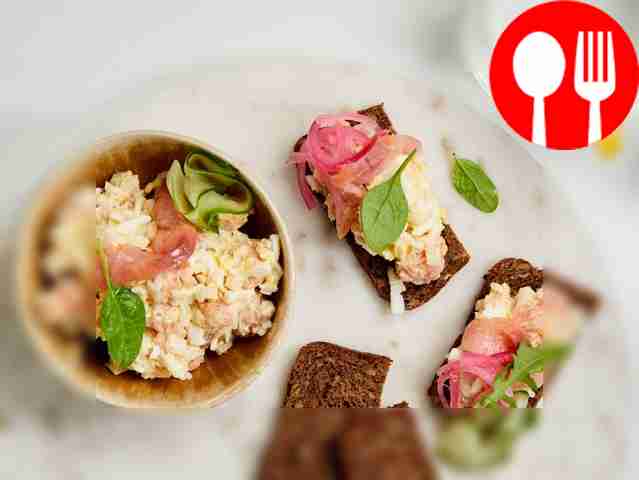 Рыбный салат с рисом и яйцом украсьте веточкой кинзы.