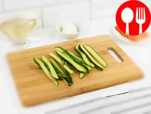 Нарежьте огурец длинными тонкими ломтиками...