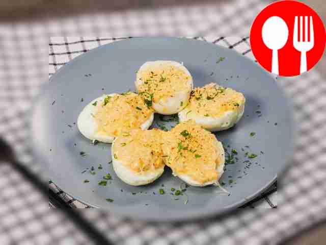 Разложите фаршированные яйца по сервировочному...