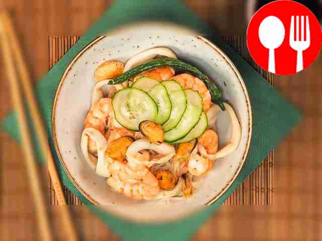 Сверху порций вока с морепродуктами уложите...