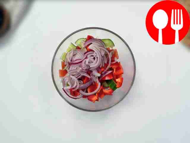 Поместите в глубокий салатник помидоры,...