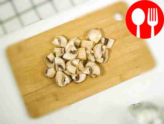 Разделите шампиньоны на четыре части.