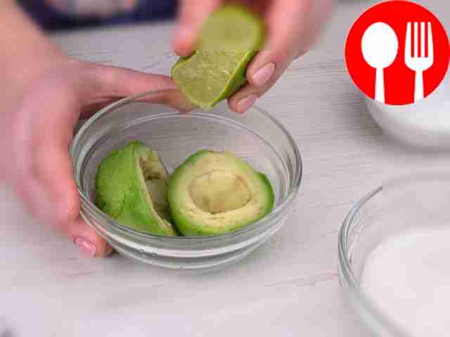 Положите авокадо в миску, полейте соком лайма...