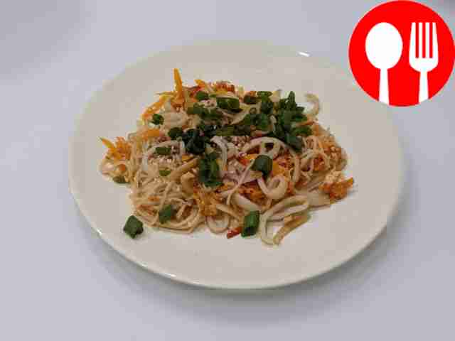 Аппетитный кальмар с рисовой лапшой на сковороде