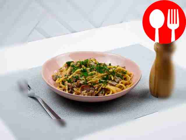 Украсьте пасту свежими листьями базилика....