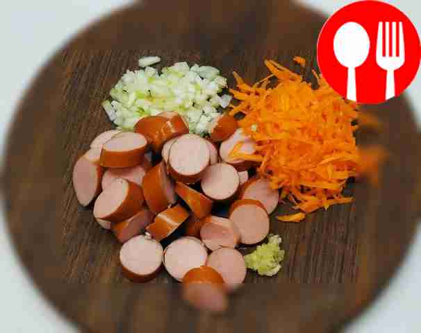 Очистите сосиски от пленки и нарежьте лук....