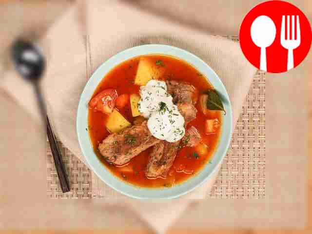 Готовую шурпу из свиных ребрышек разлейте по...